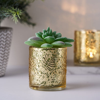 Gold decorative planter with succulent plant on a marble surface.
