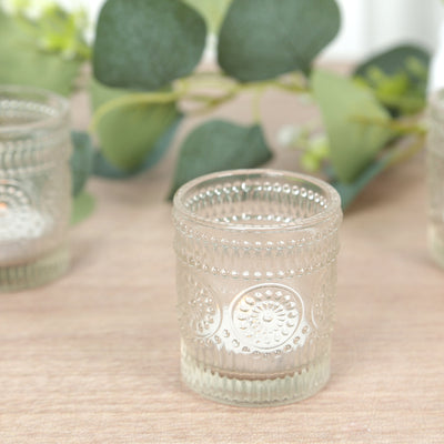 Decorative glass candle holder with embossed design and clear finish.