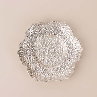 Decorative silver plate with intricate floral patterns.