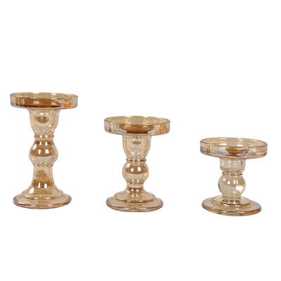 Set of three clear glass candle holders in varying heights.