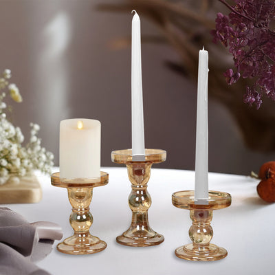 Elegant glass candle holders with candles, perfect for home decor.