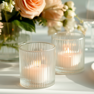Elegant ribbed glass candle holders with soft glowing candles.