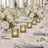 Elegant white wedding table with floral centerpieces and green candle holders