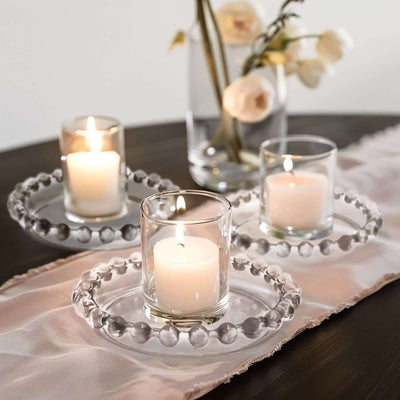 Elegant candle holders with soft-lit candles on a decorative table setting.