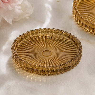 Gold glass decorative coaster with scalloped edge and radial sunburst design