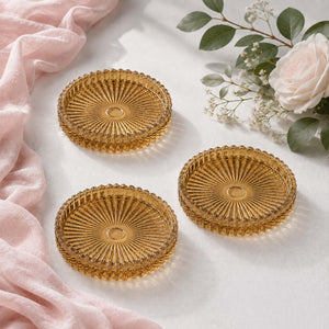 Gold glass dessert plates with floral decor on a white tablecloth