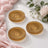 Gold glass dessert plates with floral decor on a white tablecloth