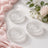 Elegant clear glass coasters with pink fabric and white roses on a soft background