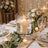 Elegant wedding table centerpiece with candles, roses, and gold table settings