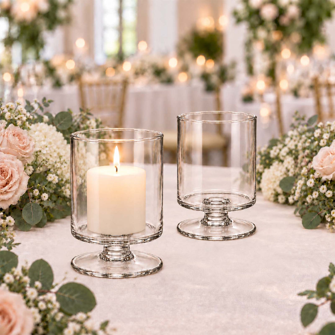 Elegant glass candle holders on a floral wedding reception table centerpiece