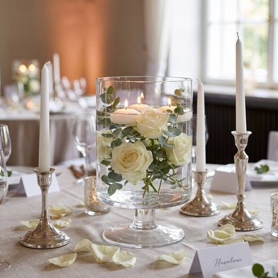 Elegant white rose centerpiece with floating candles on a wedding table