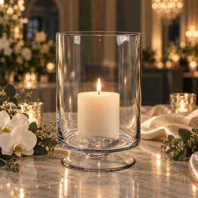 Elegant white pillar candle in a glass hurricane centerpiece on a wedding table