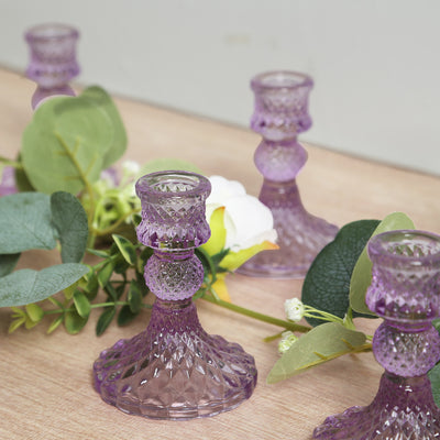 Purple crystal candle holders with greenery accents.