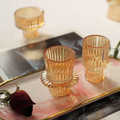 Elegant amber glass tumblers on a decorative tray with a rose.