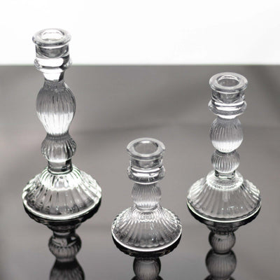 Set of three elegant glass candlesticks in varying heights.