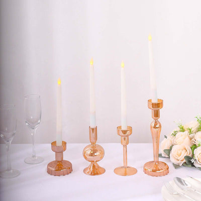 Elegant glass candle holders with white candles on a table setting.