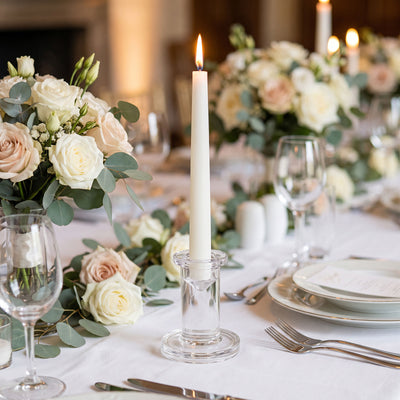 Elegant wedding table centerpiece with roses, candles, and gold table settings