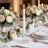 Elegant wedding table centerpiece with roses, candles, and gold table settings