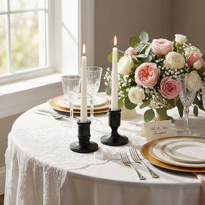 Elegant wedding table setting with roses, candles, and gold-rimmed plates