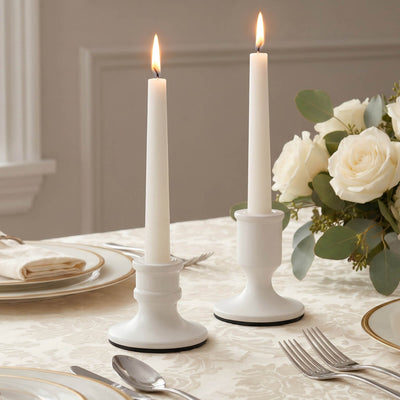 Elegant white taper candles with roses on a wedding table setting