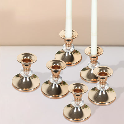 Set of elegant rose gold candle holders with crystal accents.