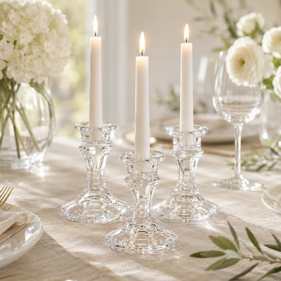 Elegant white taper candles in crystal candle holders on a wedding table setup