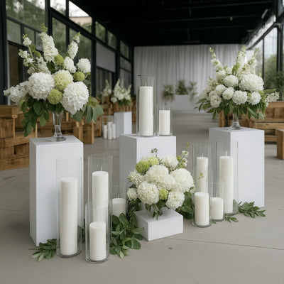 Elegant white floral arrangements and candles in a stylish event setting.