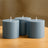 Three blue cylindrical candles on a wooden table.