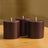 Brown pillar candles arranged on a wooden table.