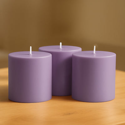 Purple cylindrical candles arranged on a wooden surface.