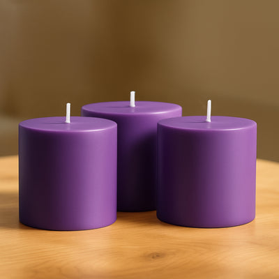 Purple cylindrical candles arranged on a wooden surface.