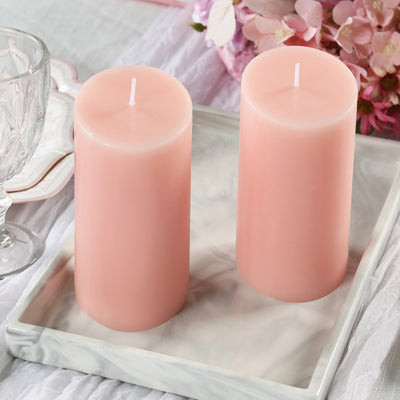 Pink scented candles on a marble tray with floral decor.
