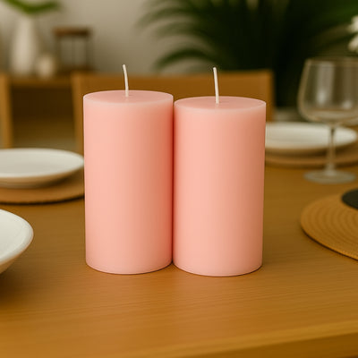 Pink pillar candles on a dining table with decorative elements.