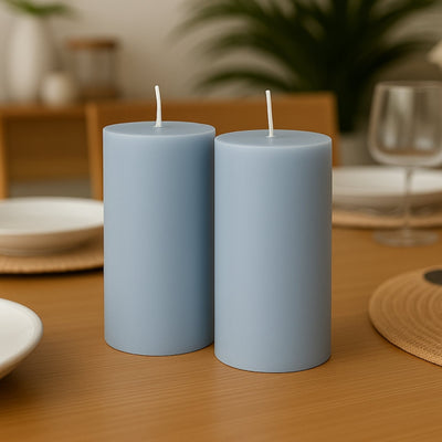 Blue cylindrical candles on a dining table setting.