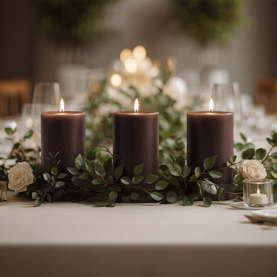 Elegant purple candles with greenery and roses on a beautifully set dining table.