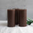 Set of three dark brown cylindrical candles with green foliage