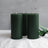 Green pillar candles with a subtle matte finish against a soft background.