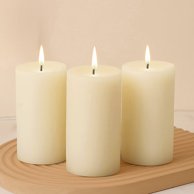 Set of three ivory pillar candles with flickering flames.
