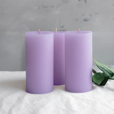 Lavender pillar candles arranged with greenery accent