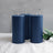 Three navy blue pillar candles arranged together on a soft surface.