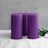 Purple pillar candles grouped together with greenery
