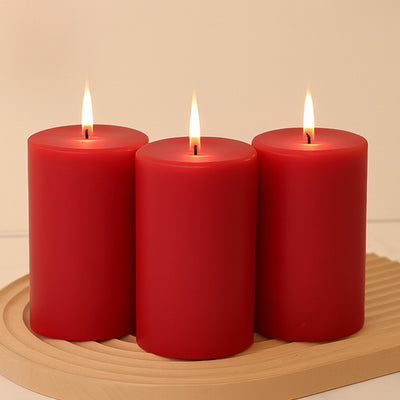 Three red candles with flames, arranged on a wooden tray.