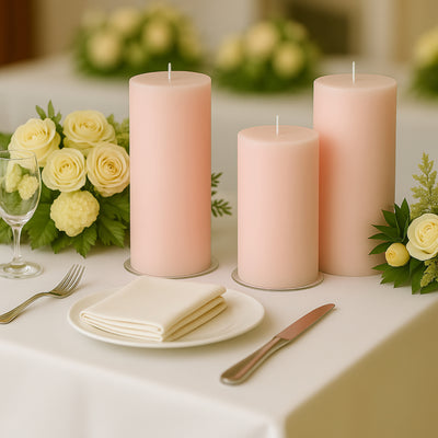Pink pillar candles on a table with white dinnerware and yellow floral accents.