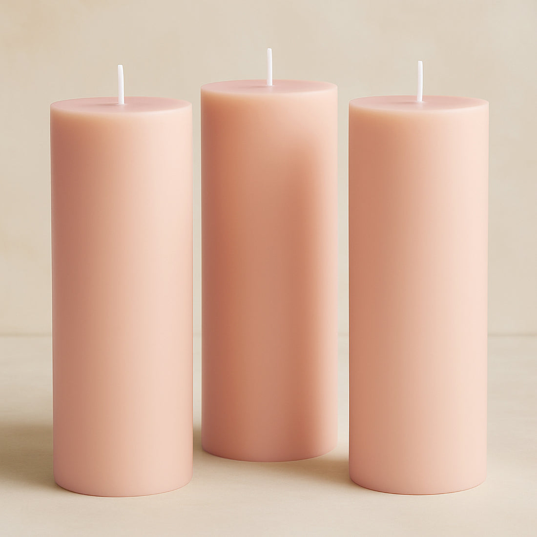 Set of three soft pink pillar candles in varying heights.