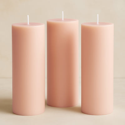 Set of three soft pink pillar candles in varying heights.