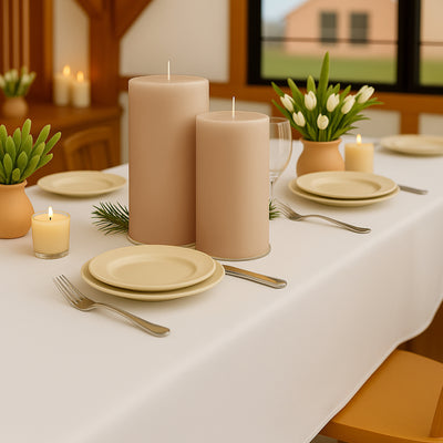 Elegant table setting with candles, plates, and fresh flowers in a cozy dining space.