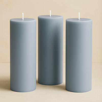 Set of three gray pillar candles in varying heights.
