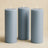 Set of three gray pillar candles in varying heights.
