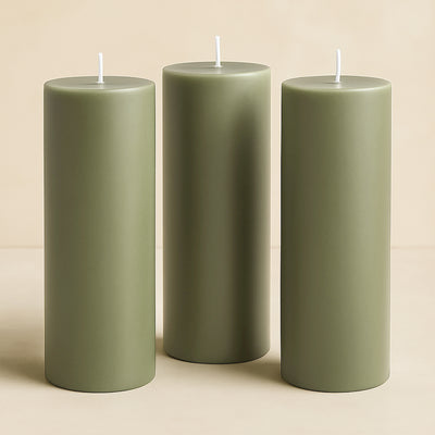 Set of three green pillar candles in varying heights.