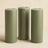 Set of three green pillar candles in varying heights.
